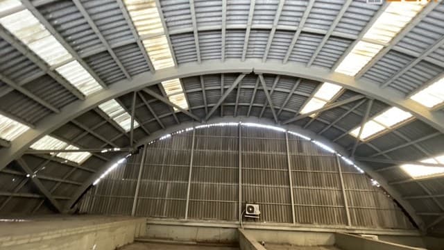 Interior d'una nau amb coberta corba d'amiant-ciment
