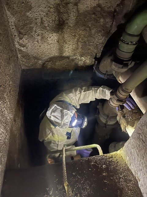 Tècnic amb equip de protecció inspeccionant una galeria de serveis subterrània