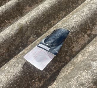 Mostra embossada i etiquetada sobre una coberta d'amiant-ciment